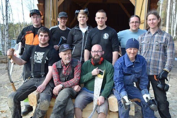 Gruppbild på kursdeltagare med sågar och yxor