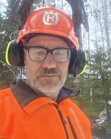 Ola Andersson i hjälm och skyddsjacka ute i skogen